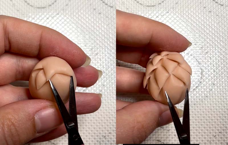 Cutting into the polymer clay egg shape to make dragon scales