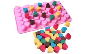 Mini wax melt hearts next to pink mini heart shaped silicone mould