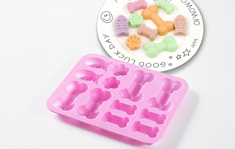 silicone dog treat molds and dog treats on a white plate