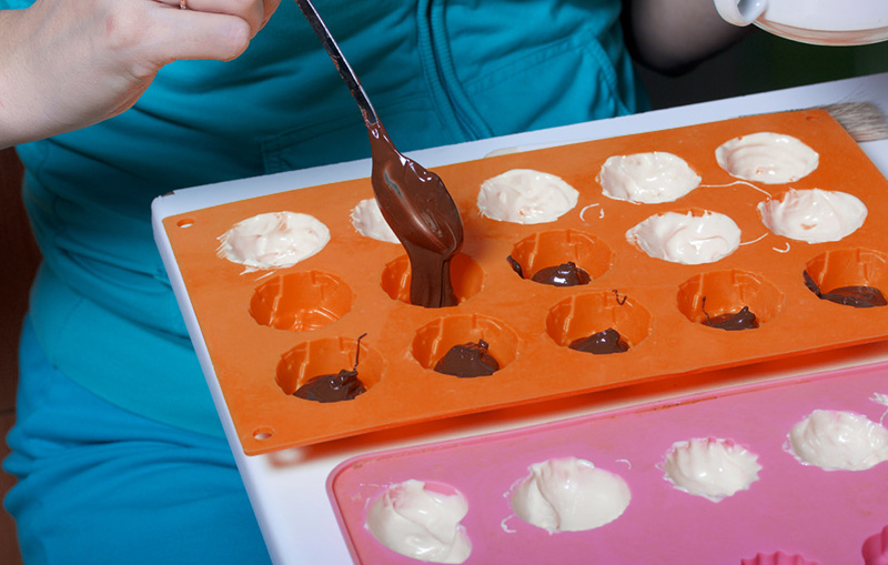 Filling silicone moulds with melted chocolate