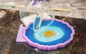 pouring epoxy resin into a silicone mould, creating resin art