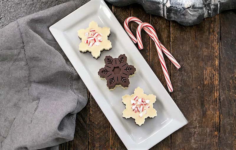 Christmas peppermint bark in fun snowflake shapes on a rectangular plate.