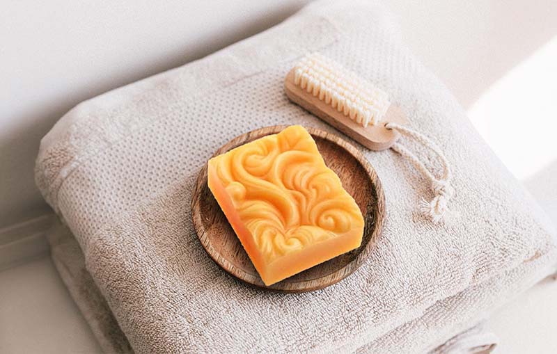 Orange homemade soap on a bathroom towel