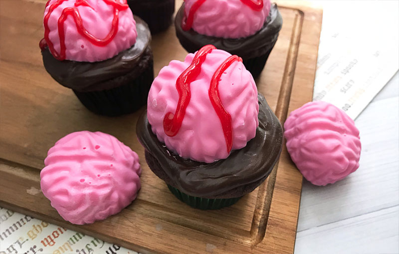 Pink brain cupcakes made with silicone molds for spooky Halloween baking ideas.