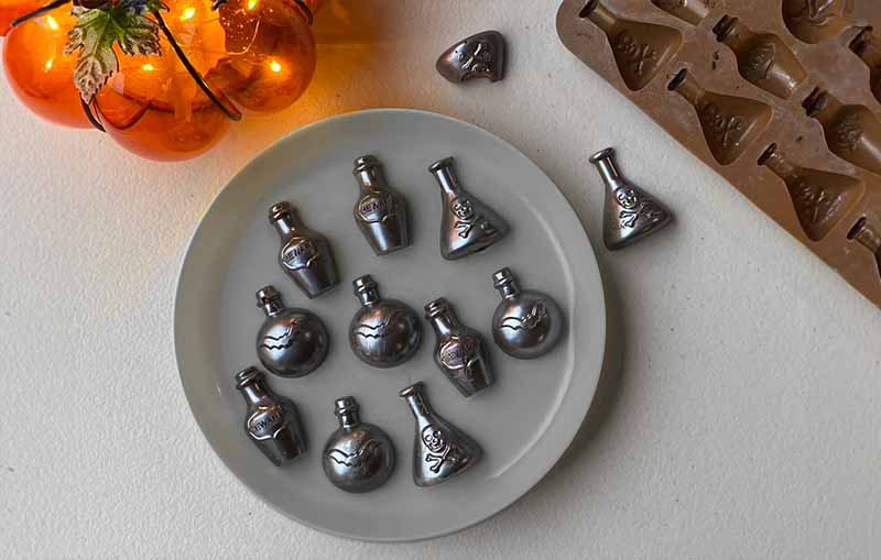 Poison bottle-shaped chocolates made with silicone molds for spooky Halloween baking ideas.