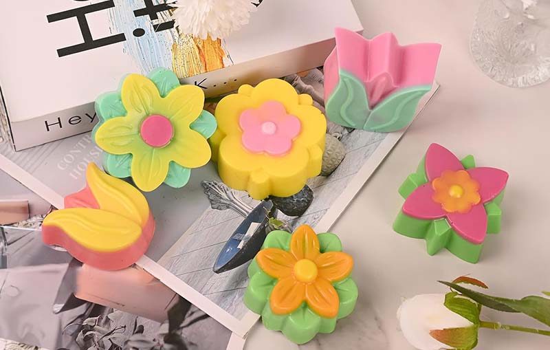handmade soaps in different colours and floral shapes - formed using a soap silicone mold