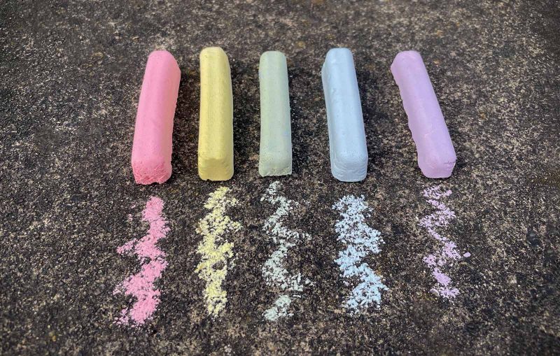 Homemade Sidewalk Chalk in different colours on the pavement